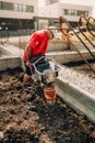 Construction worker compacting soil with vibration compaction machinery