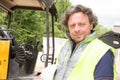 Portrait construction worker in front of excavator