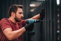 construction worker installing metal elements using cordless screwdriver