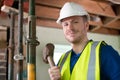 Portrait Of Construction Worker With Sledgehammer Demolishing Wall In Renovated House