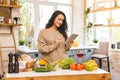 Portrait of cooking healthy food young woman in kitchen looking for a recipe on the Internet. Using tablet computer Royalty Free Stock Photo