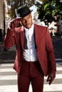 Cool african american male fashion model posing on city street with vintage suit and hat Royalty Free Stock Photo
