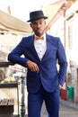 Cool african american male model posing on city street with suit and bowtie