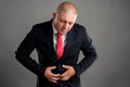 Businessman dressed in black suit having the stomach pain Royalty Free Stock Photo