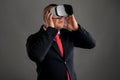 Businessman dressed in black suit wearing virtual reality VR glasses Royalty Free Stock Photo