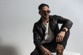 Cool fashion guy with leather jacket and sunglasses looking away Royalty Free Stock Photo