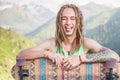 Portrait of cool, funny handsome man with skateboard at mountain