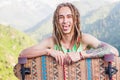 Portrait of cool, funny handsome man with skateboard at mountain