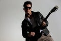 cool guitarist with leather jacket and sunglasses playing guitar Royalty Free Stock Photo