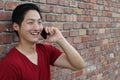 Portrait of a cool guy sitting on sidewalk calling by mobile phone Royalty Free Stock Photo