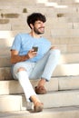 Cool guy sitting on steps with cell phone Royalty Free Stock Photo
