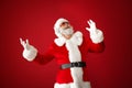 Portrait of cool Santa Claus listening to music on color background Royalty Free Stock Photo