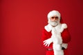 Portrait of cool Santa Claus listening to music on color background Royalty Free Stock Photo