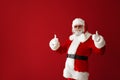 Portrait of cool Santa Claus showing thumb-up on color background Royalty Free Stock Photo