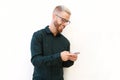 Cool young man with glasses looking at mobile phone Royalty Free Stock Photo