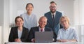 Portrait of corporate business team working on laptop and smiling at camera Royalty Free Stock Photo