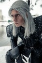 Portrait of cosplayer in image of character Geralt of Rivia from the game or film The Witcher with sword behind his back