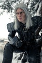 Portrait of cosplayer in image of character Geralt of Rivia from the game or film The Witcher in winter forest