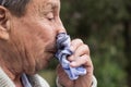 Portrait of a coughing senior man outdoors, looking down Royalty Free Stock Photo