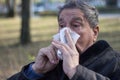 Portrait of a coughing senior man outdoors, looking down Royalty Free Stock Photo