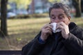 Portrait of a coughing senior man outdoors, looking down Royalty Free Stock Photo