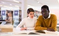 Portrait of couple of adult students studying together in public library Royalty Free Stock Photo