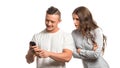 Portrait of couple. Angry upset woman holding arms crossed and looks over husband`s s shoulder at his phone. Man looking Royalty Free Stock Photo