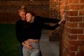 Romantic couple young beautiful sensual redhead woman and tall handsome blonde man posing in sunset sunlight on red Royalty Free Stock Photo