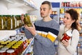 Portrait of an couple buying a salted tomatoes and cucumbers at grocery store Royalty Free Stock Photo