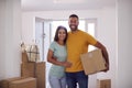 Portrait Of Couple Carrying Boxes Through Front Door Of New Home On Moving Day Royalty Free Stock Photo