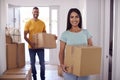 Portrait Of Couple Carrying Boxes Through Front Door Of New Home On Moving Day Royalty Free Stock Photo