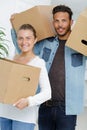 portrait couple carrying boxes into new apartment