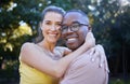 Portrait, couple on a date and hug with love in nature, outdoor in park with commitment in interracial relationship Royalty Free Stock Photo