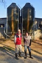 Portrait of a couple farmers on the outside of a grange with grain storege