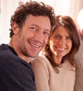 Portrait, couple and happy on a sofa together, bond, relax and smile in living room in their home. Love, family and face Royalty Free Stock Photo