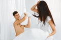 Portrait of couple having a pillow fight in bed Royalty Free Stock Photo