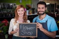 Portrait of couple holding slate with flower shop sign Royalty Free Stock Photo