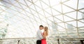 Portrait of couple kissing and hugging inside transparent building. Love story, walks in Warsaw. Poland