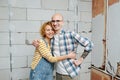 Portrait of a couple in love inside an apartment under construction.