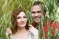 Portrait of a couple in love in the willow branches. Happy married couple on a walk in the park