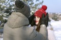 Portrait of couple in love in winter outside. Guy straightens his beloved girl hat