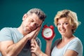 A portrait of couple in the morning. Woman holding alarm clock, while man sleeping. People, relationships and emotions concept Royalty Free Stock Photo