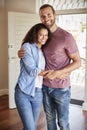 Portrait Of Couple By Open Front Door In Lounge Of New Home Royalty Free Stock Photo