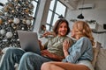 Portrait of couple paying online purchases with credit card on laptop. Christmas time Royalty Free Stock Photo