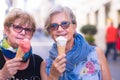 Portrait of a couple of pretty senior women looking at the camera and smiling with an ice cream cone in their hands. Two people Royalty Free Stock Photo
