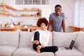 Portrait Of Couple Relaxing On Sofa At Home Looking At Laptop Together