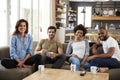Portrait Of Couple Sitting On Sofa With Friends At Home Talking Royalty Free Stock Photo
