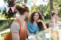 Portrait of couple sitting at the table with family and friends at the family garden party. Royalty Free Stock Photo