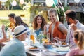 Portrait of couple sitting at the table with family and friends at the family garden party. Royalty Free Stock Photo