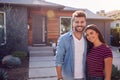 Portrait Of Couple Standing Outdoors In Front Of House With For Sale Sign In Garden Royalty Free Stock Photo